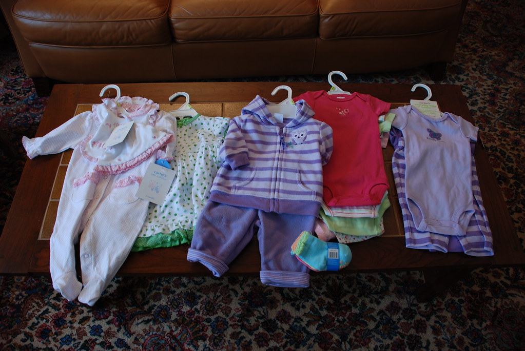 Baby clothes laid out on a table